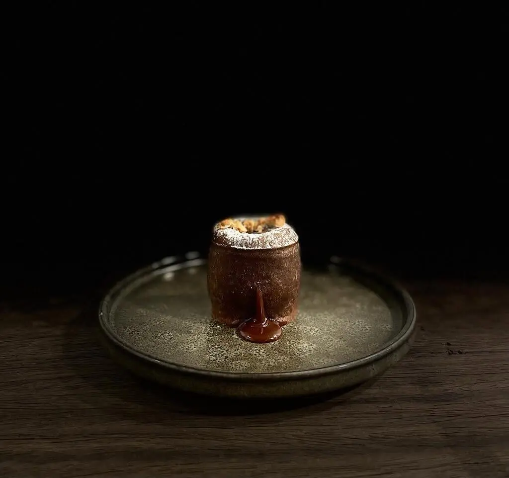 Moelleux au chocolat et boule de glace dans un récipient noir.